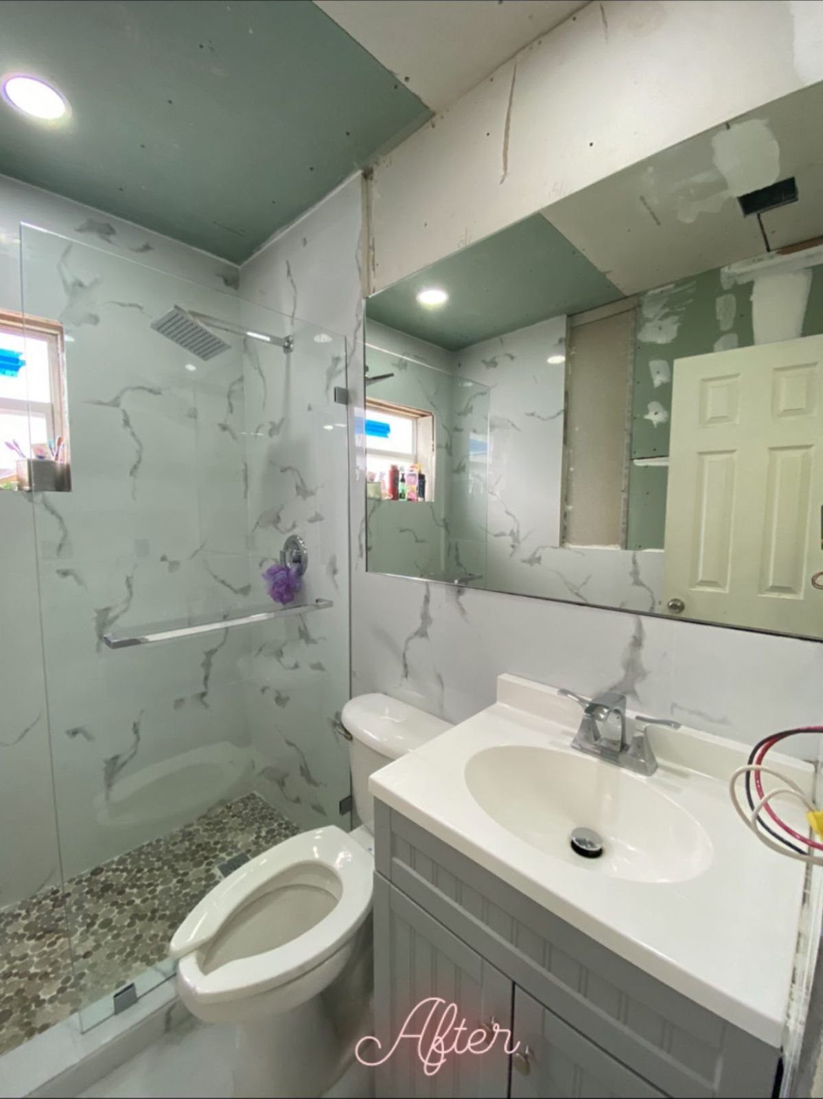 Finished bathroom with frameless shower panel and mirror