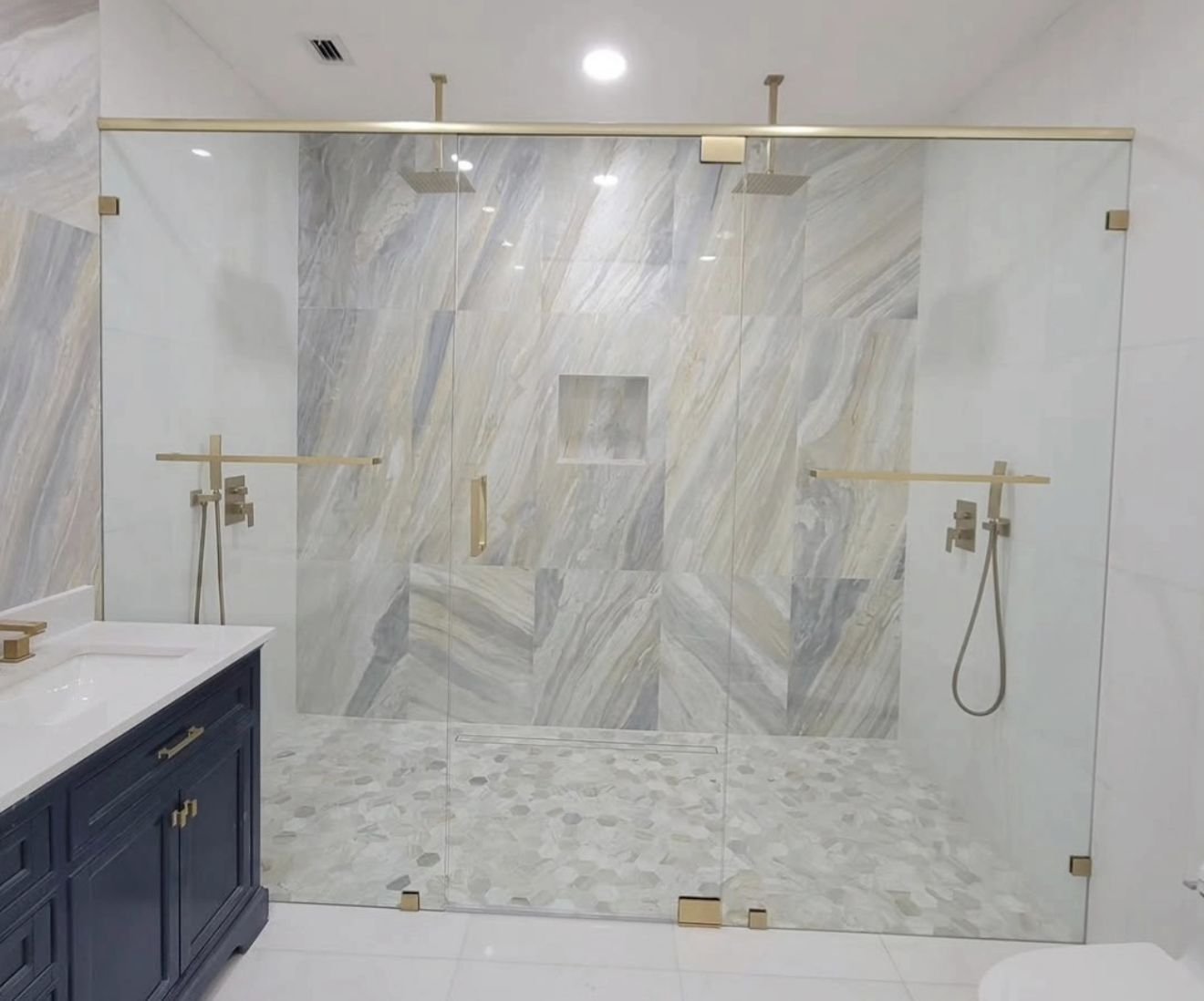 Double walk-in shower with brushed gold hardware